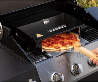 A Cuisinart Grill Top Pizza Oven making a pepperoni pizza