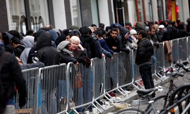 British people wait outside London&amp;#039;s flagship Apple store on Sept. 20.