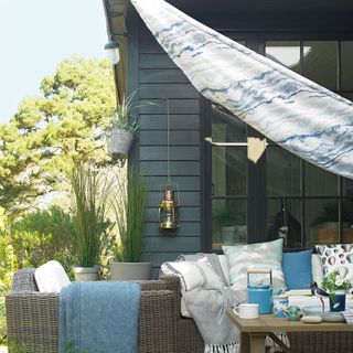 Outdoor seating covered by a blue tie-dye shade sail