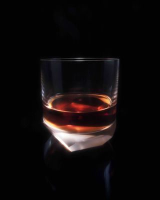 Rum in glass against a black background