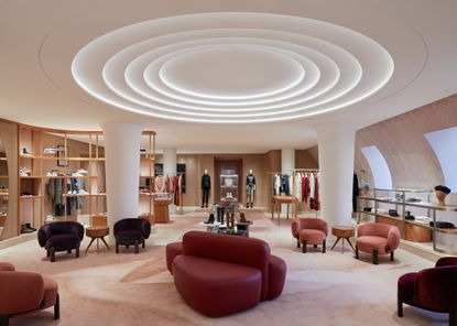 An interior photograph of Hermes Madison Avenue with leather chairs and circular light installation