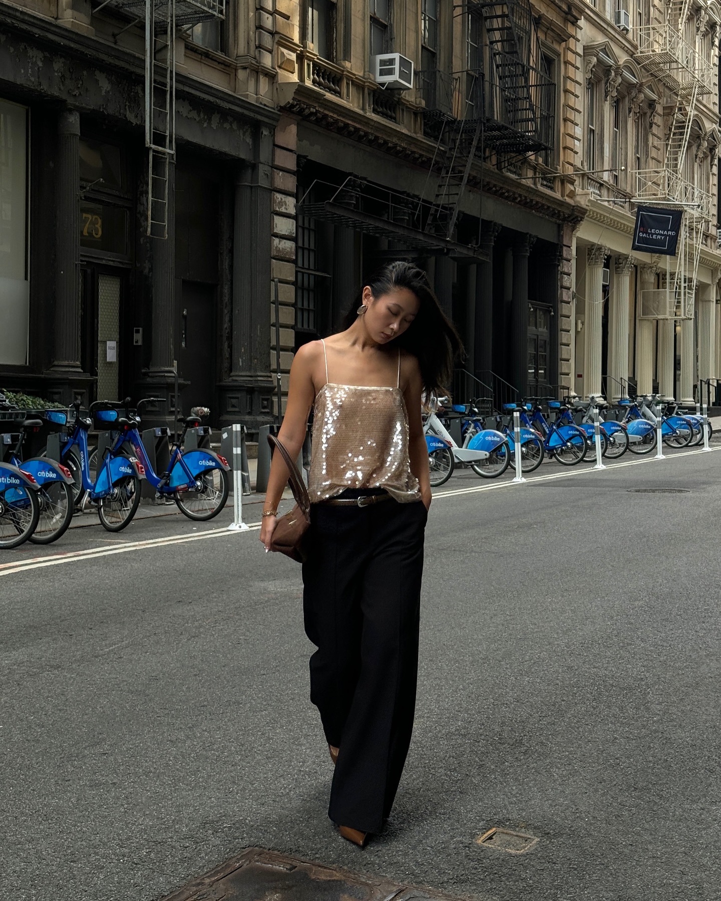 An image of @thecarolinelin wearing a sequin top with black trousers.