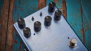 A Fender tremolo pedal lying on a wooden floor