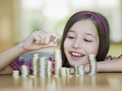 Child piling coins on table