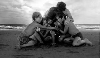 Roma the family huddles together on the beach