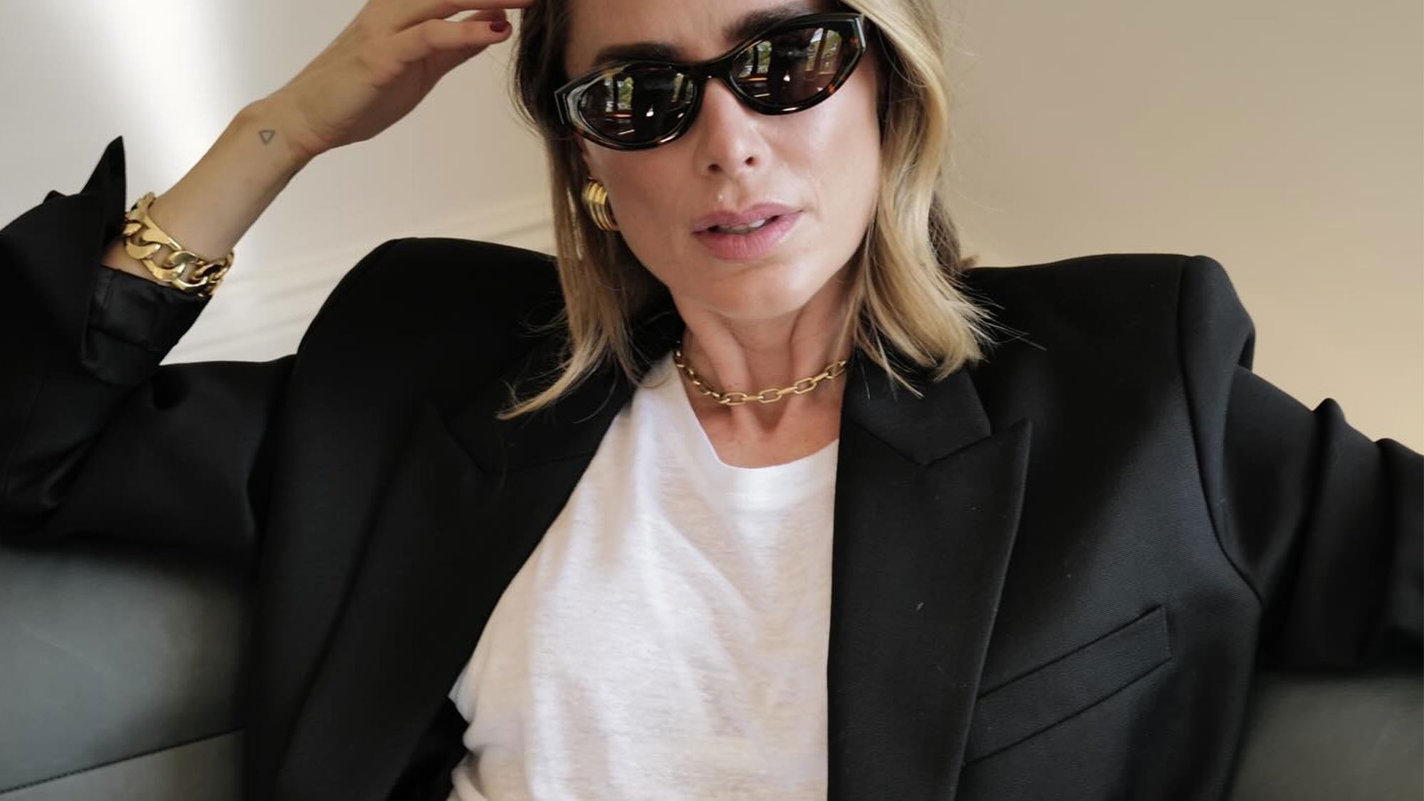 Anine Bing wearing a white tee, black blazer, and gold jewelry.