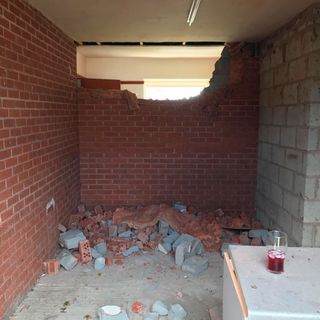 garage with red brick broken wall and siporex wall and table
