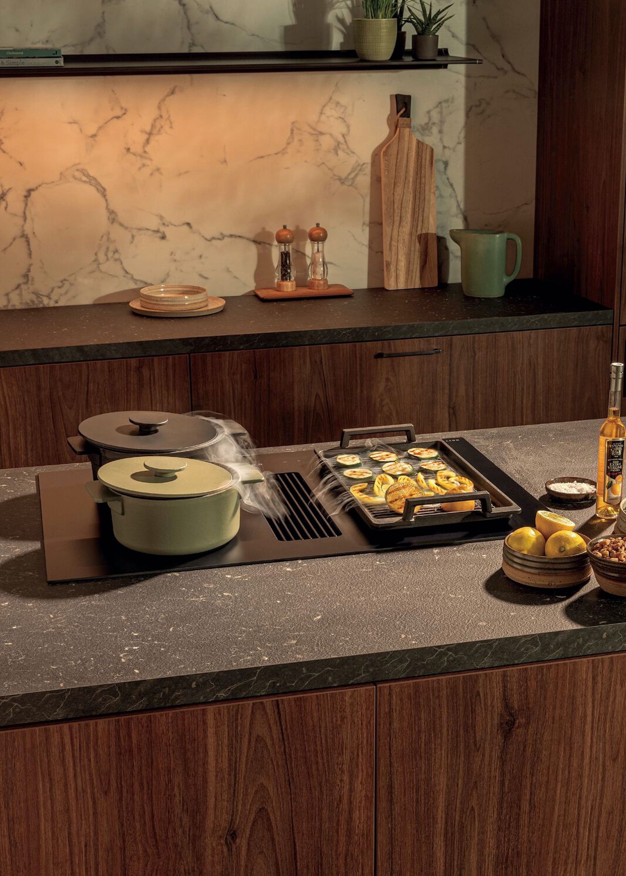 induction hob loaded with pans in a walnut kitchen