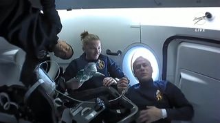 The astronauts of SpaceX's Crew 3 mission for NASA discuss life inside the Crew Dragon Endurance on their ride to the International Space Station on Nov. 11, 2021. Seen here are (from left) Crew-3 commander Raja Chari, mission specialist Kayla Barron and pilot Tom Marshburn, all of NASA. Not pictured is European Space Agency astronaut Mattias Maurer, who was holding the camera.