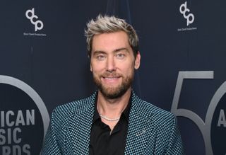 lance bass of nsync posts on a red carpet