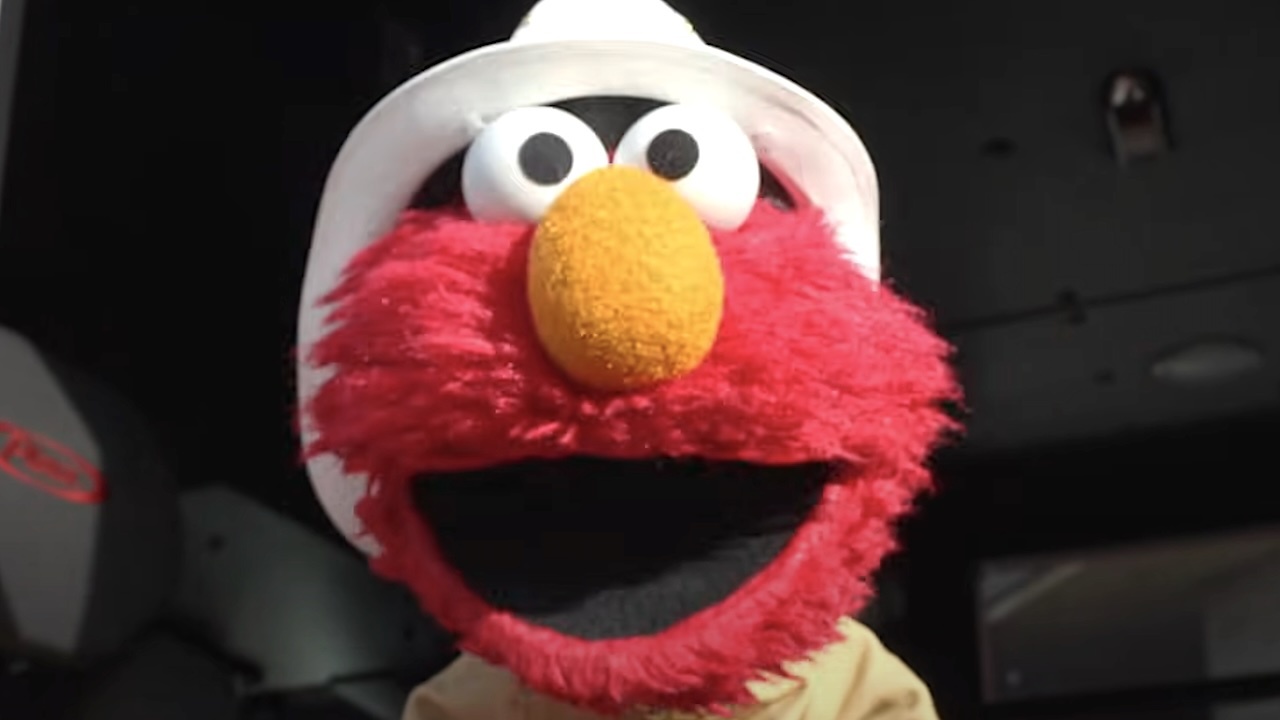Elmo wearing a hat and smiling