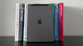 Apple iPad 10,2 stöttas upp av lite böcker.