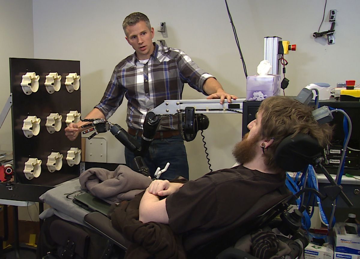 Researcher Rob Gaunt prepares Nathan Copeland for brain computer interface sensory test.