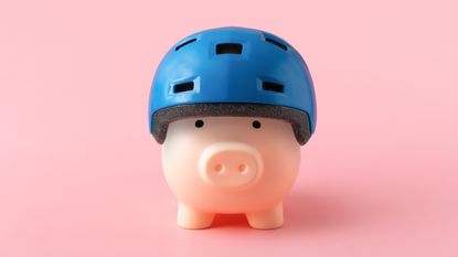 A piggy bank wears a bike helmet.