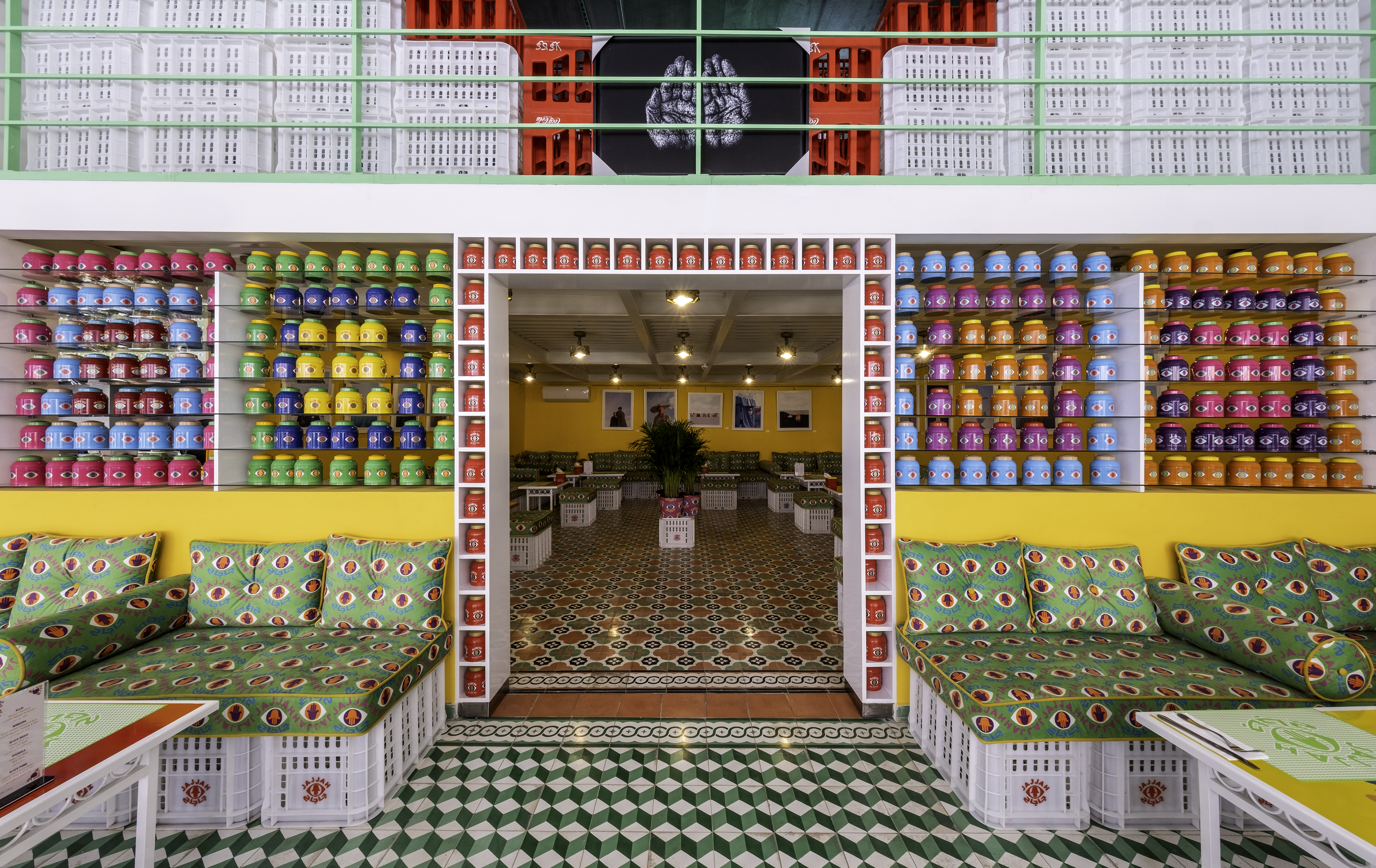 A kaleidoscopic cafe and concept store is sculpted from intricately patterned, colorful textiles, tea jars, cushions, plastic boxes, and more.