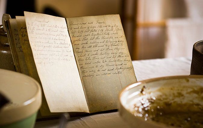 A hand-written recipe book (cookbook) by a baking bowl in a Victorian Kitchen