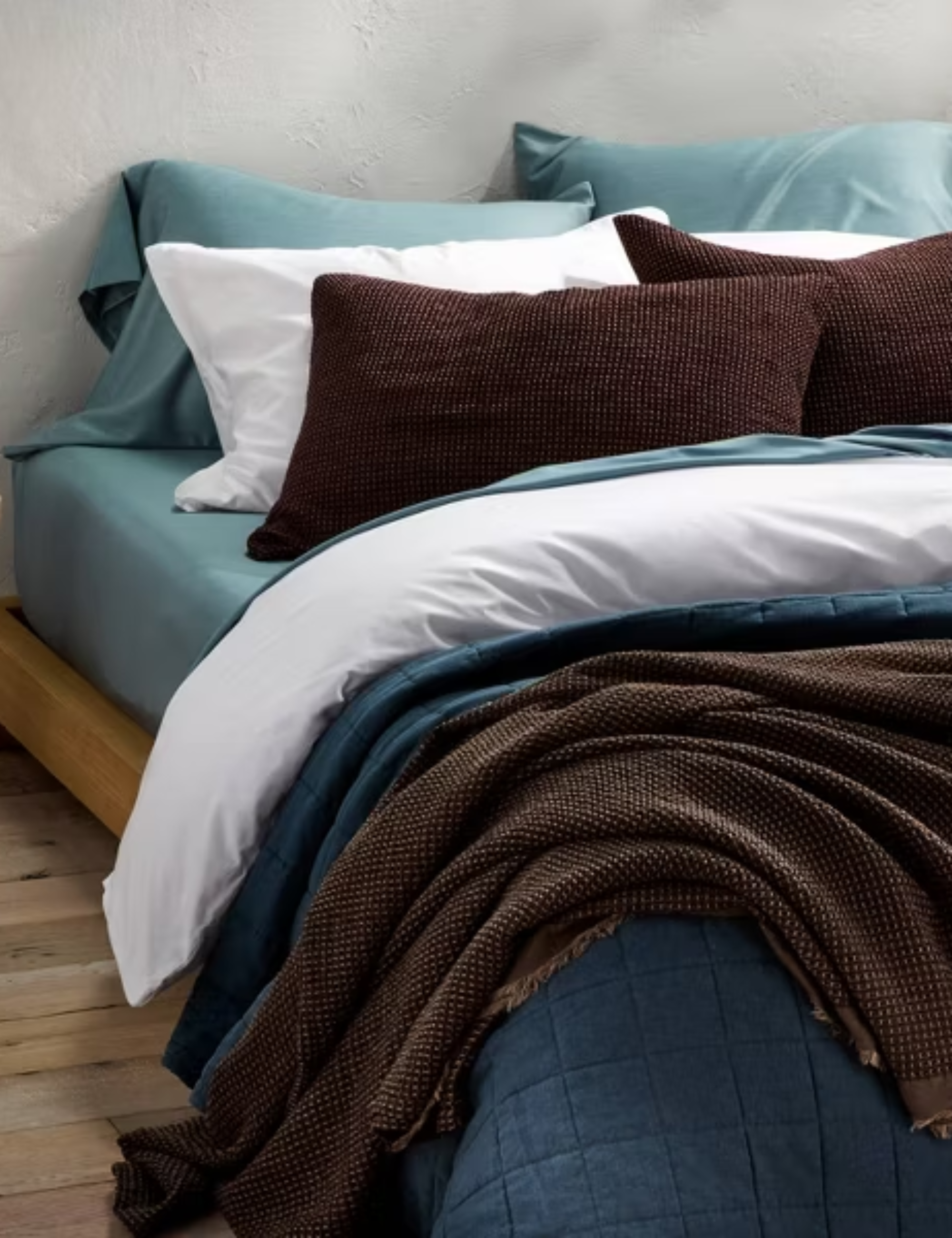 Blue and brown Casaluna bed sheets styled on a minimalist platform bed