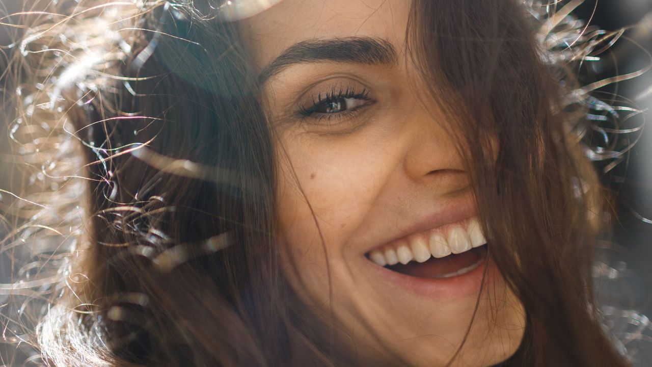 best eyebrow pens - Woman with full brows smiling at the camera - getty images 1390104940