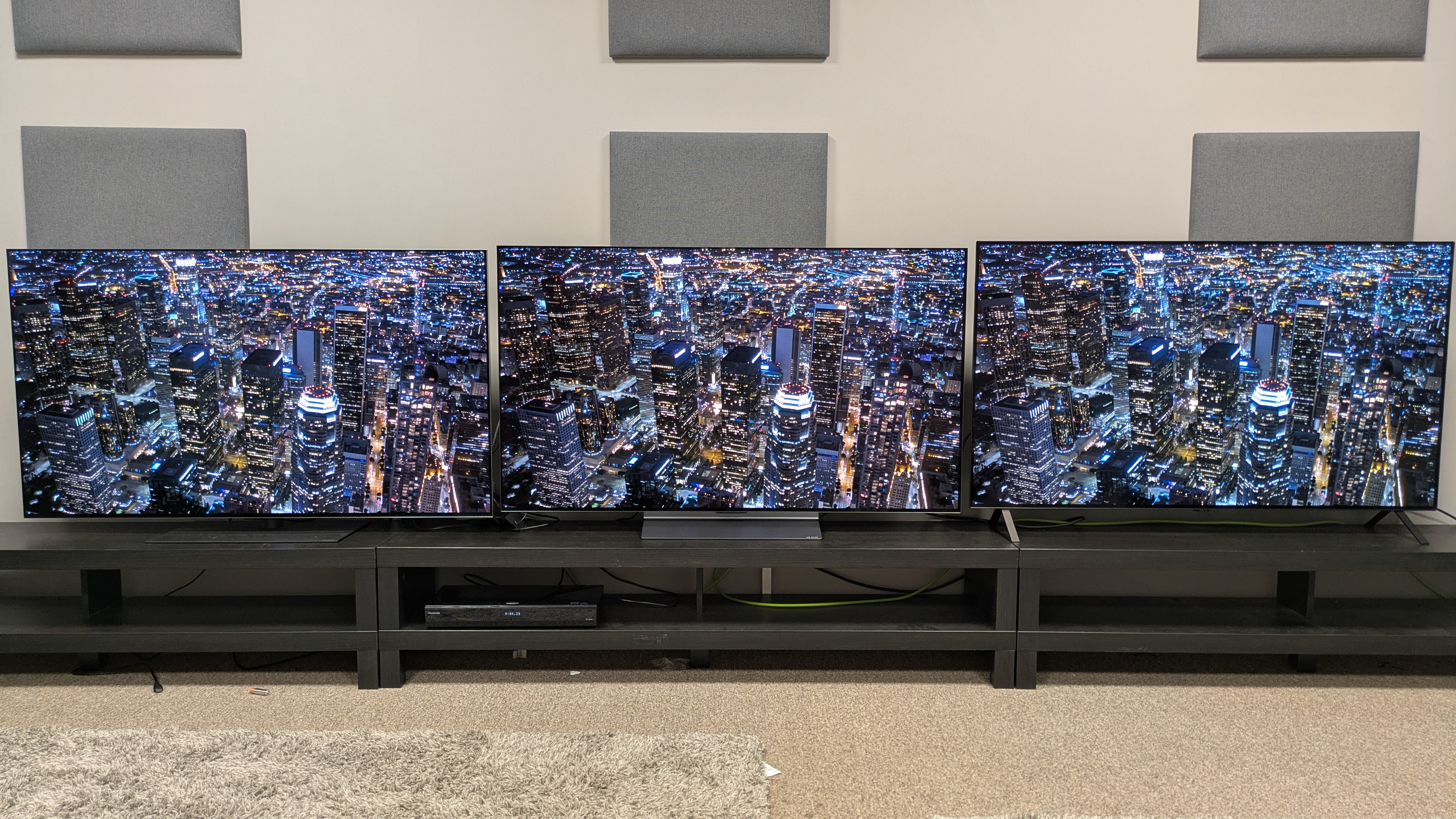 The LG G5 (left), LG C5 (middle) and LG B5 (right) showing an aerial shot of some skyscrapers on screen