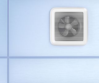 An extractor fan on a blue tile wall