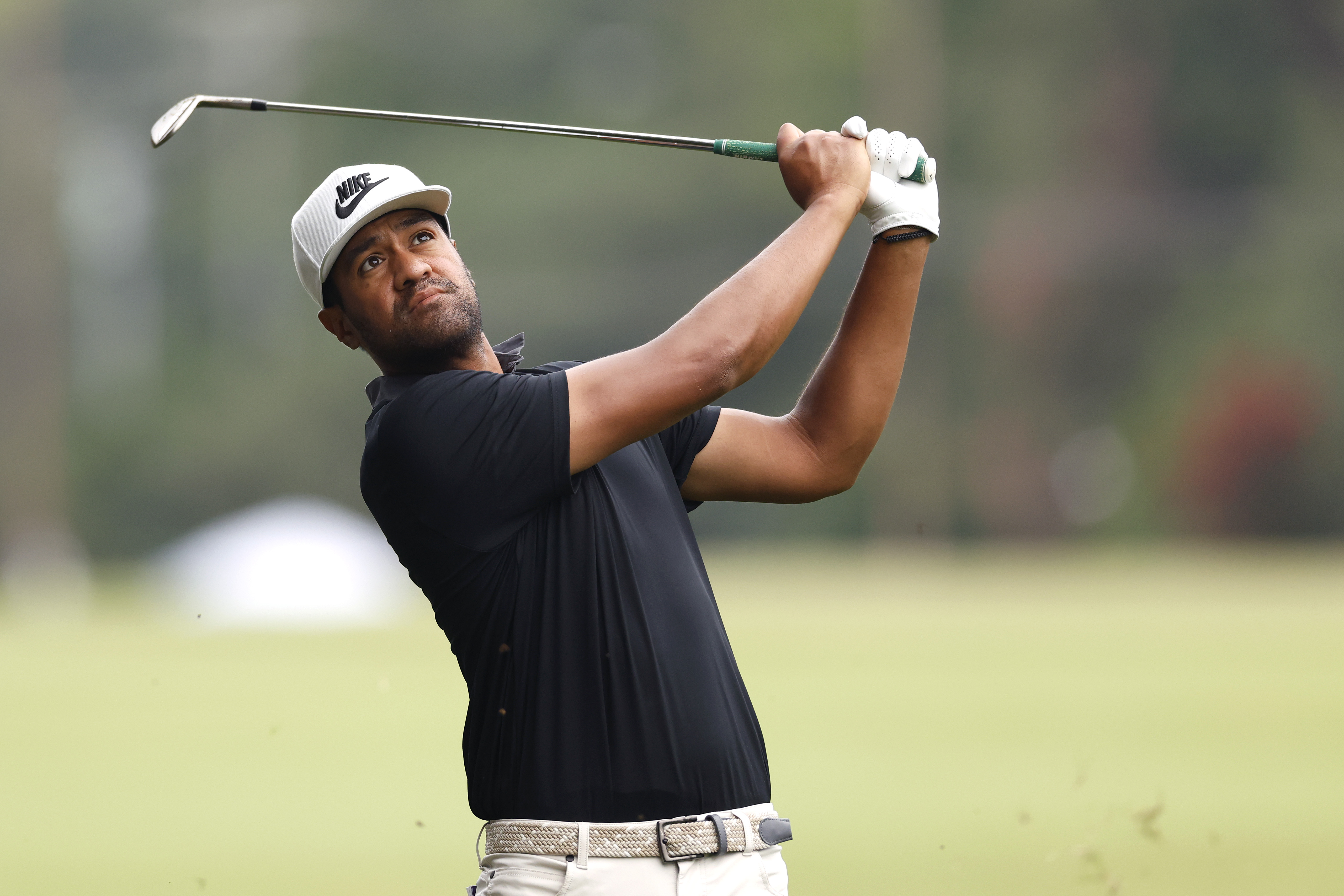 Tony Finau hits a wedge shot and watches it in the air