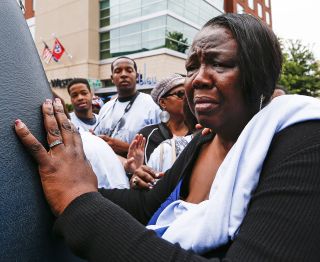 Daughter Patty King grieves as she walks with the hearse carrying her father's body, in Memphis on May 27, 2015.