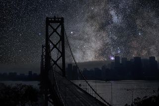 The Milky Way and California's San Francisco-Oakland Bay Bridge stand out prominently in this cityscape. The sky photo was taken in the Mojave Desert.