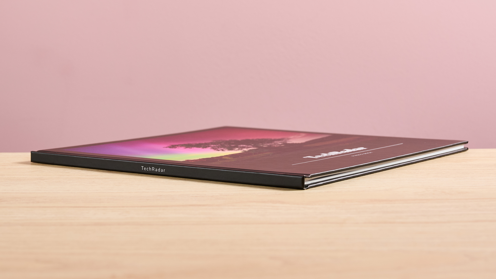 The Once Upon photo book lies on its side on a table, with the spine turned toward the camera.