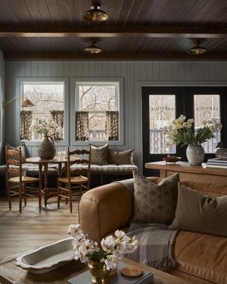 A hotel lobby space with a leather sofa and a small wooden dining table