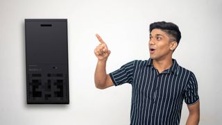 Man pointing at the back of a Xbox Series X