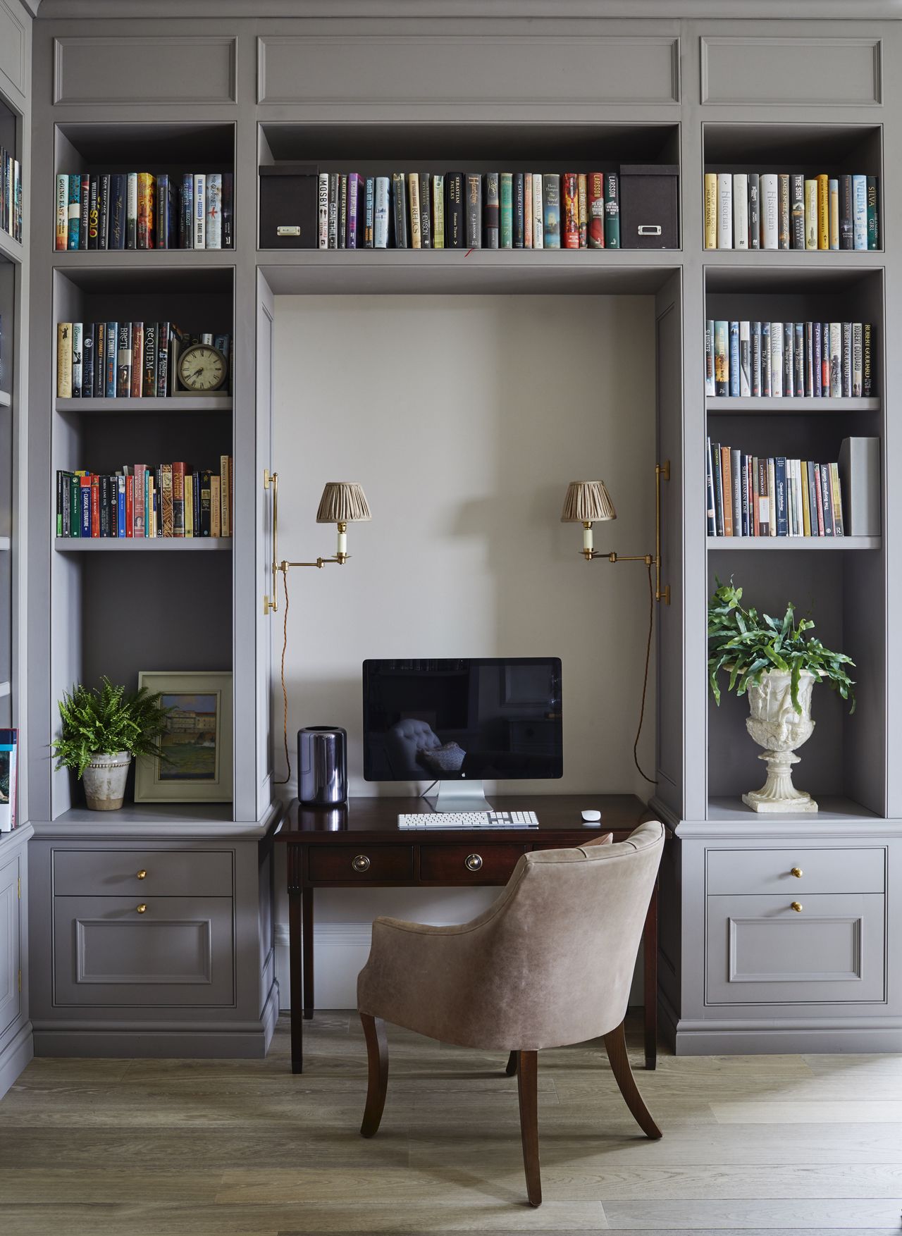 Home office with desk in niche between bespoke fitted joinery and chair