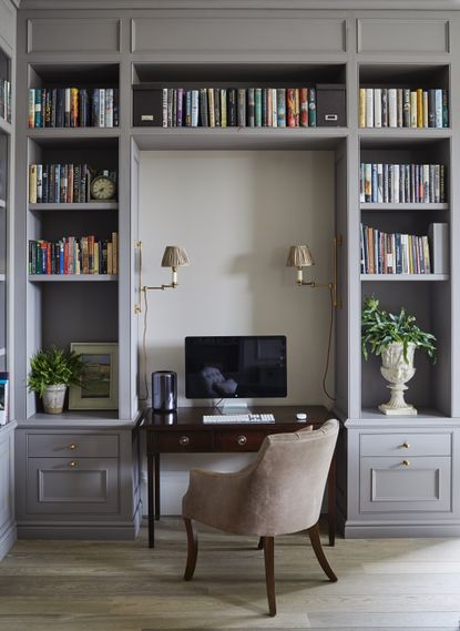Home office with desk in niche between bespoke fitted joinery and chair