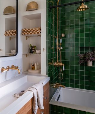 White bathroom with gold hardware and glossy tiled shower
