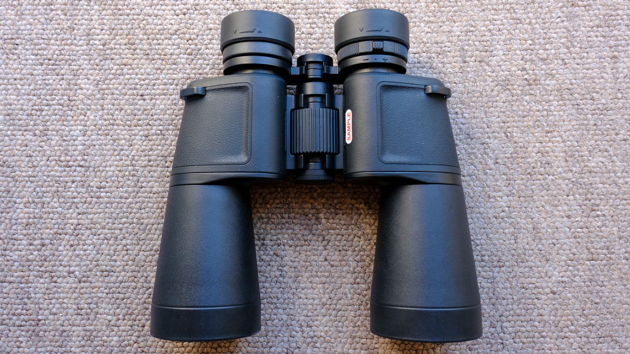 The Nikon Action 7x50 binoculars on a brown carpet, showing chassis, fousing dial and eyecups.