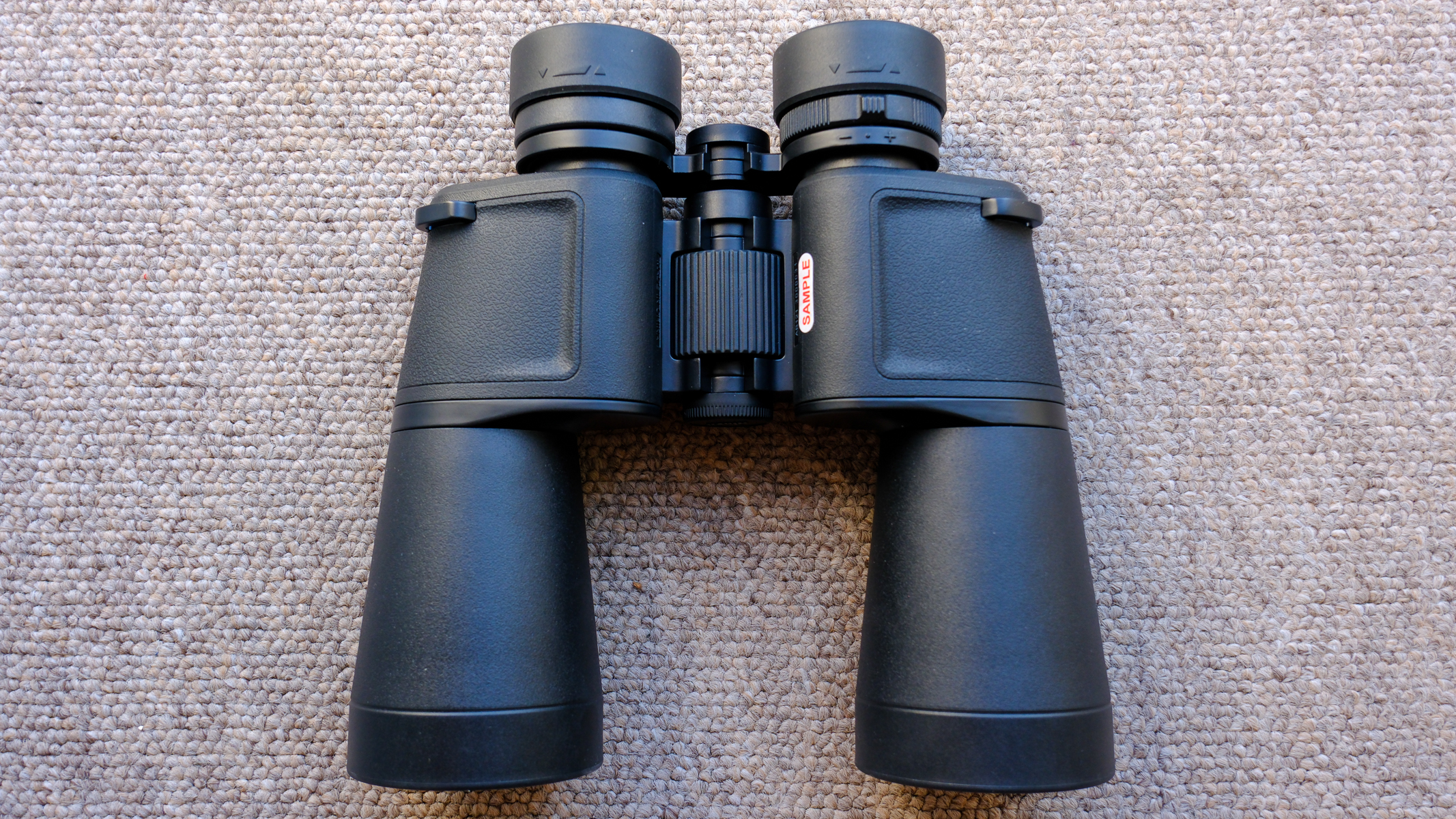 The Nikon Action 7x50 binoculars on a brown carpet, showing chassis, fousing dial and eyecups.