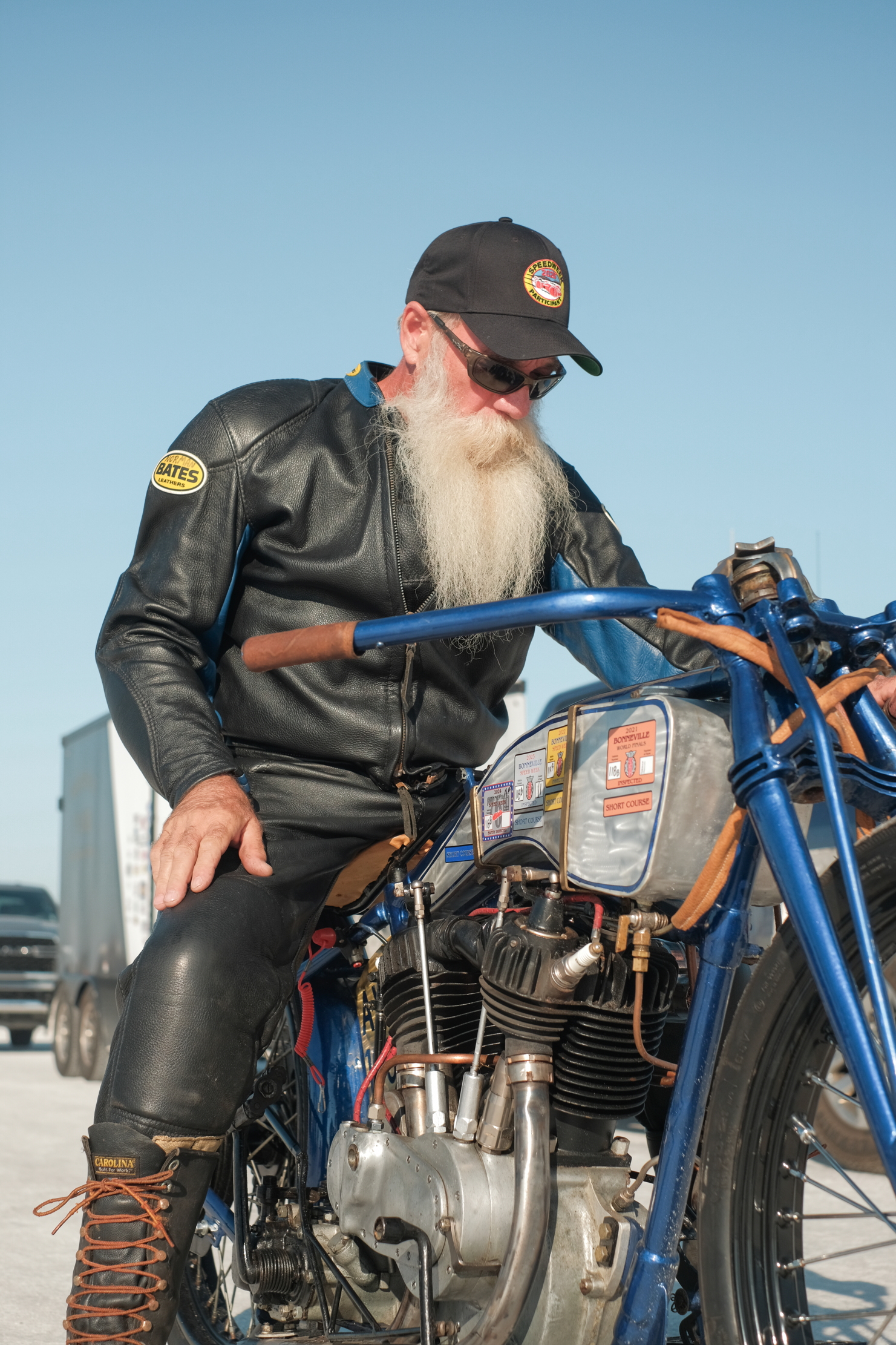 A bearded man straddles a bike