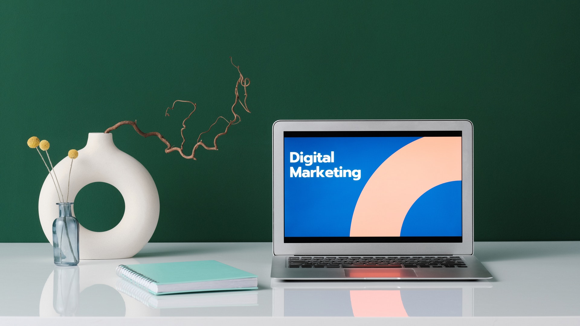 laptop terbuka di meja dengan pemasaran digital ditampilkan di layar