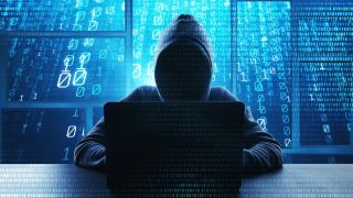 A hacker typing on a computer with binary code