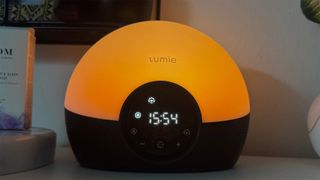 Lumie Bodyclock Glow 150 sunrise alarm clock on bedside table