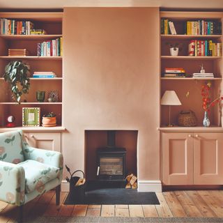 Terracotta walls with fireplace in centre, bookcases on either side