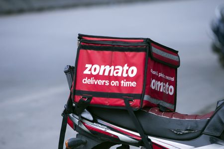 Signage for Zomato Ltd. on a cooler bag at the back of a motorcycle in Bengaluru, India