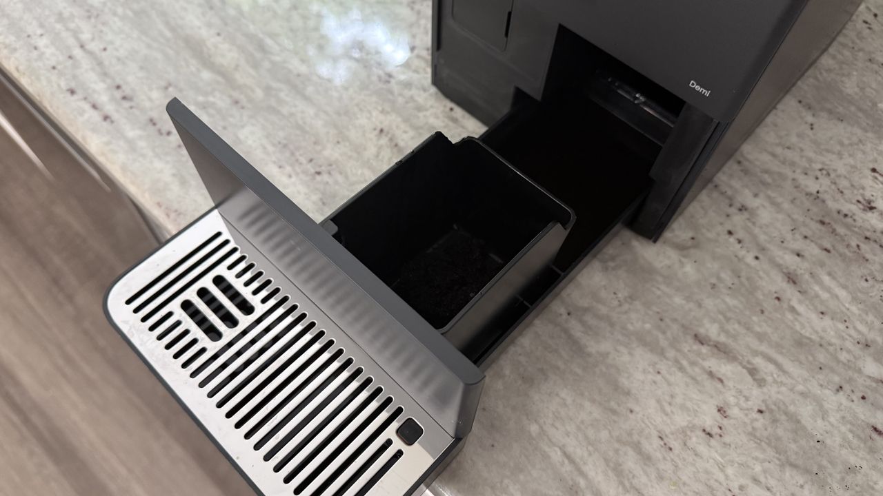 Terra Kaffe Demi cleaning out waste bin and drip tray