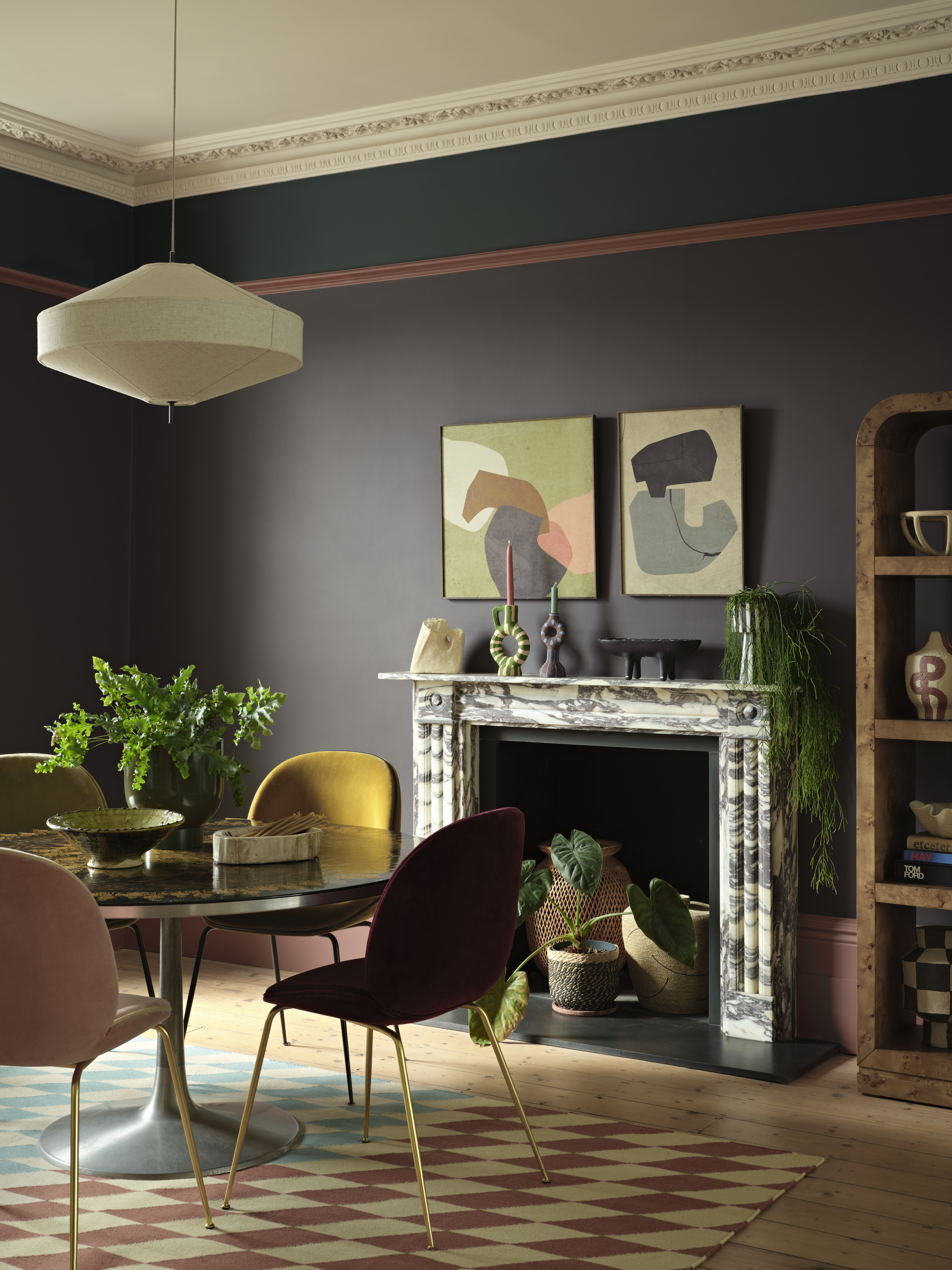An image of a dining area in front of a fireplace, with walls painted in a deep brown color.