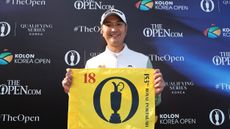 Sadom Kaewkanjana holds up The Open Championship pin flag after winning the 2025 Korea Open and qualifying for Royal Portrush