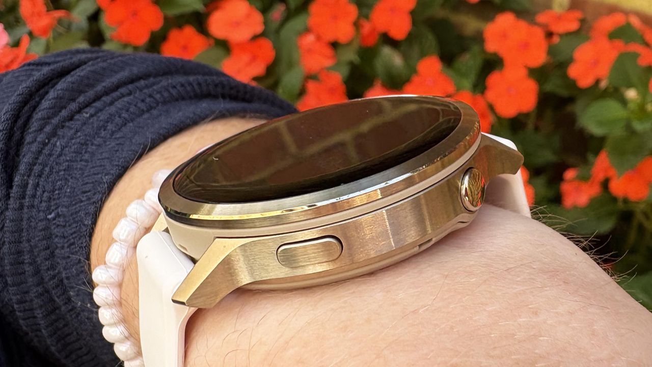the Garmin Venu 4 in lunar gold on the wrist showing the physical side buttons