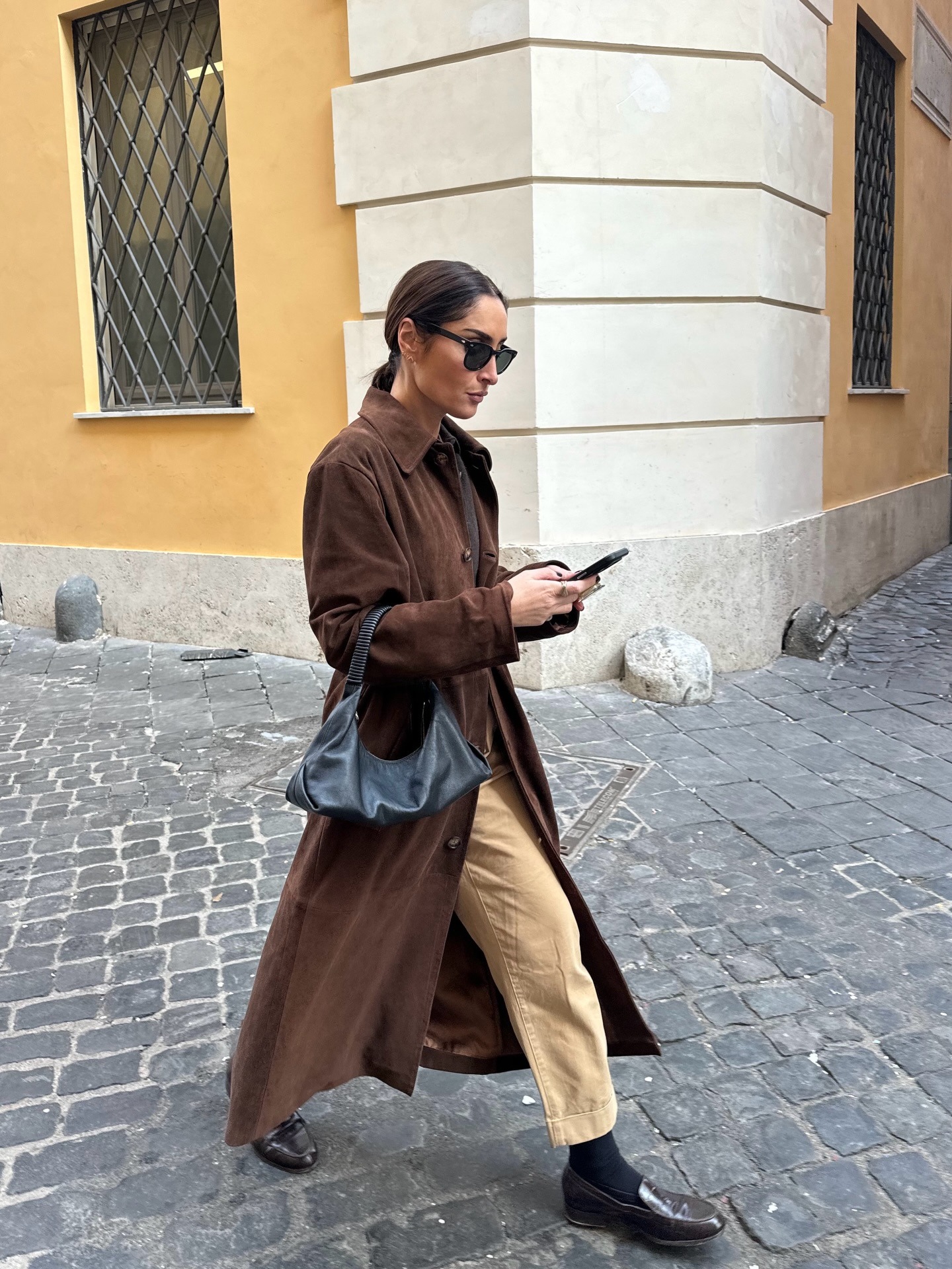 Influencer wearing dark beige pants with a suede trench and loafers