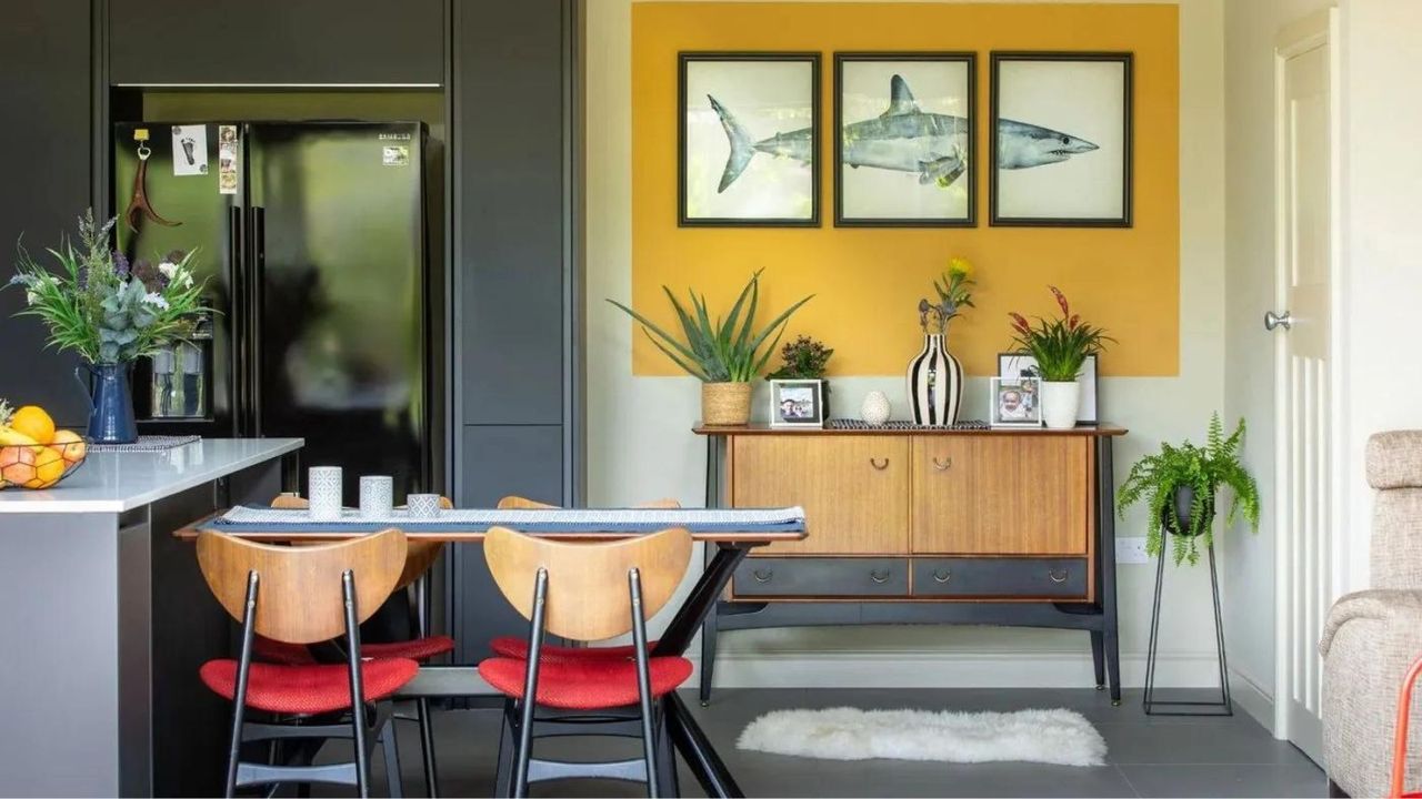 Black kitchen with yellow feature wall