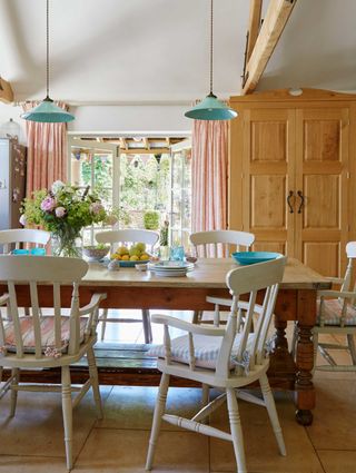 farmhouse dining room with rustic tables and chairs and beamed ceiling