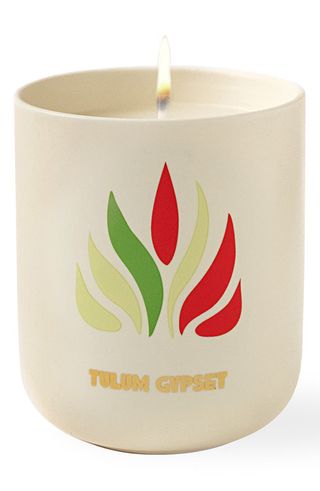 lit Assouline Travel From Home Candle on a white background 