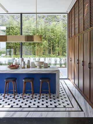 kitchen with blue island with marble worktop